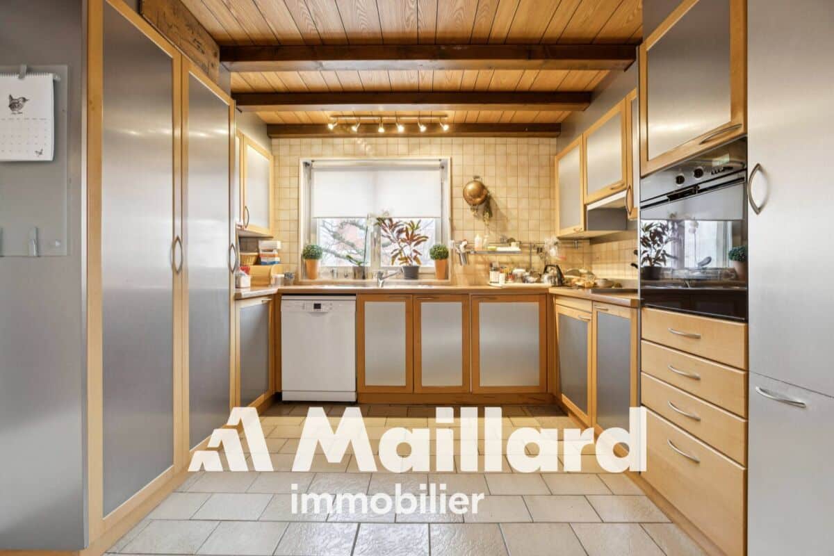 Kompakte Küche mit Holzdecke und Metallfronten