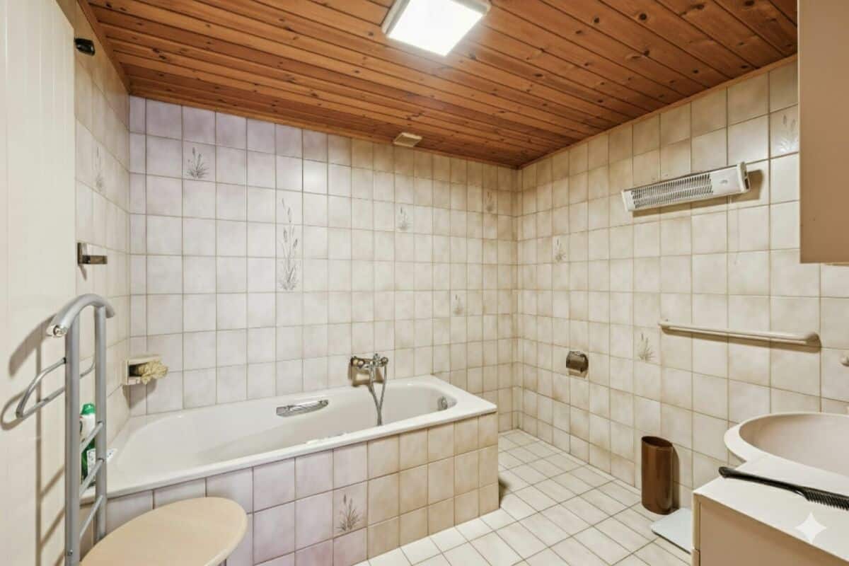 Badezimmer mit Badewanne und Holzdecke