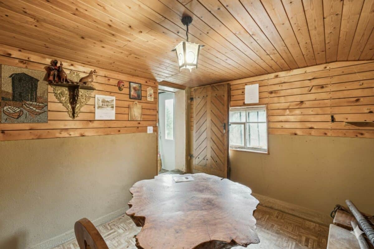 Rustikaler Innenraum mit Holzwänden und Massivholztisch