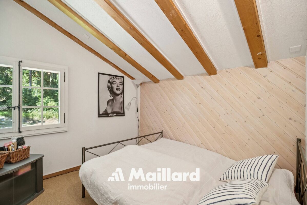 Dachgeschoss-Schlafzimmer mit sichtbaren Holzbalken