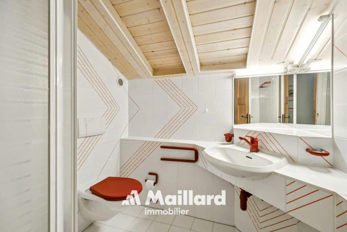 Badezimmer mit Dachschräge und rot-weißen Akzenten