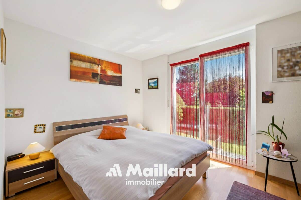 Helles Schlafzimmer mit Balkon-/Terrassentür und Blick ins Grüne