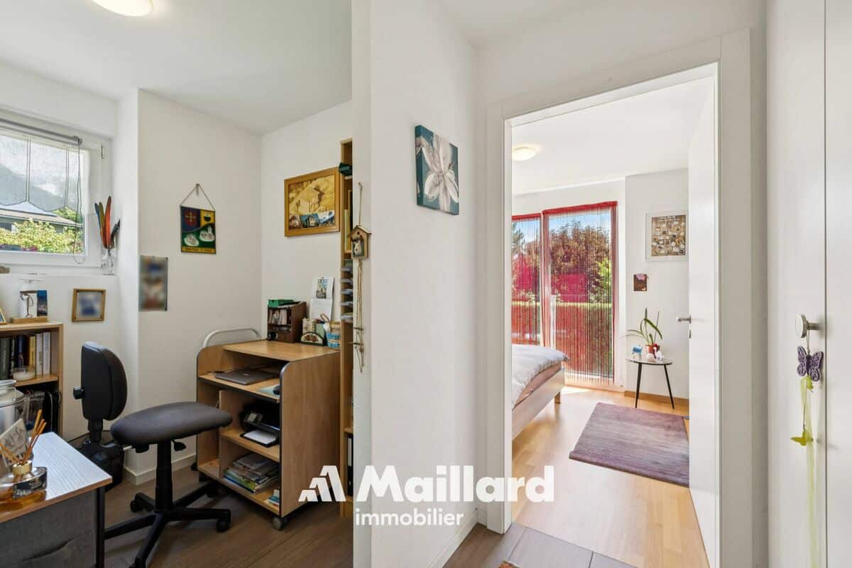 Heller Flur mit Arbeitsnische und Blick ins Schlafzimmer