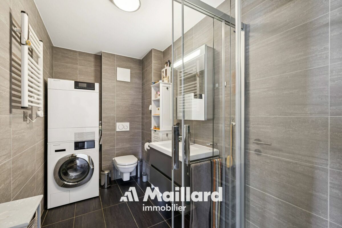 Modernes Badezimmer mit Waschmaschine und Dusche