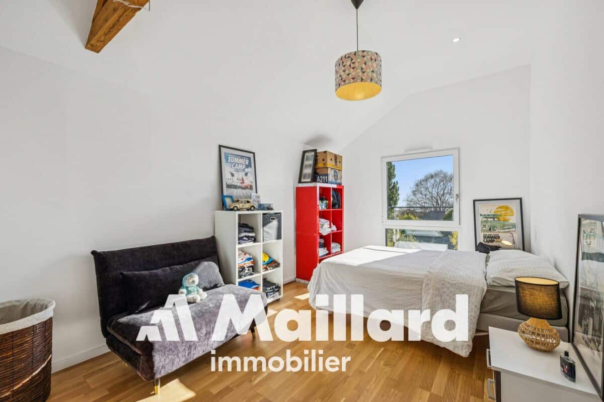 Helles Schlafzimmer mit Schrägdecke und Dachfenster