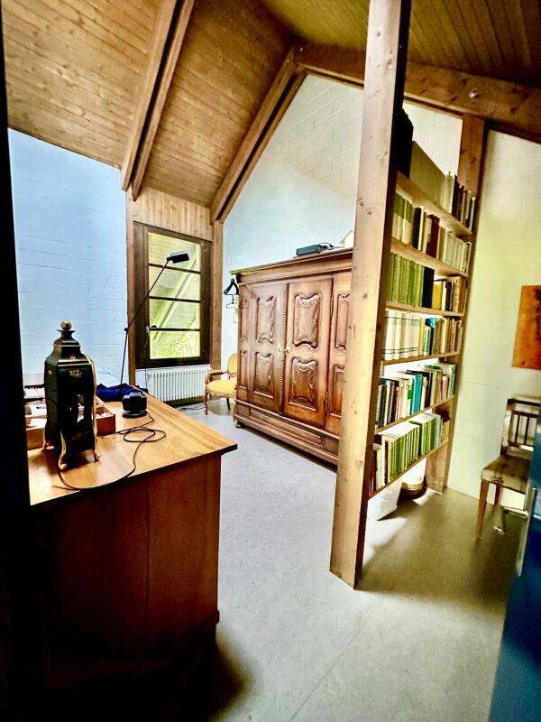 Galerieraum mit Holzdecke und Bücherregal