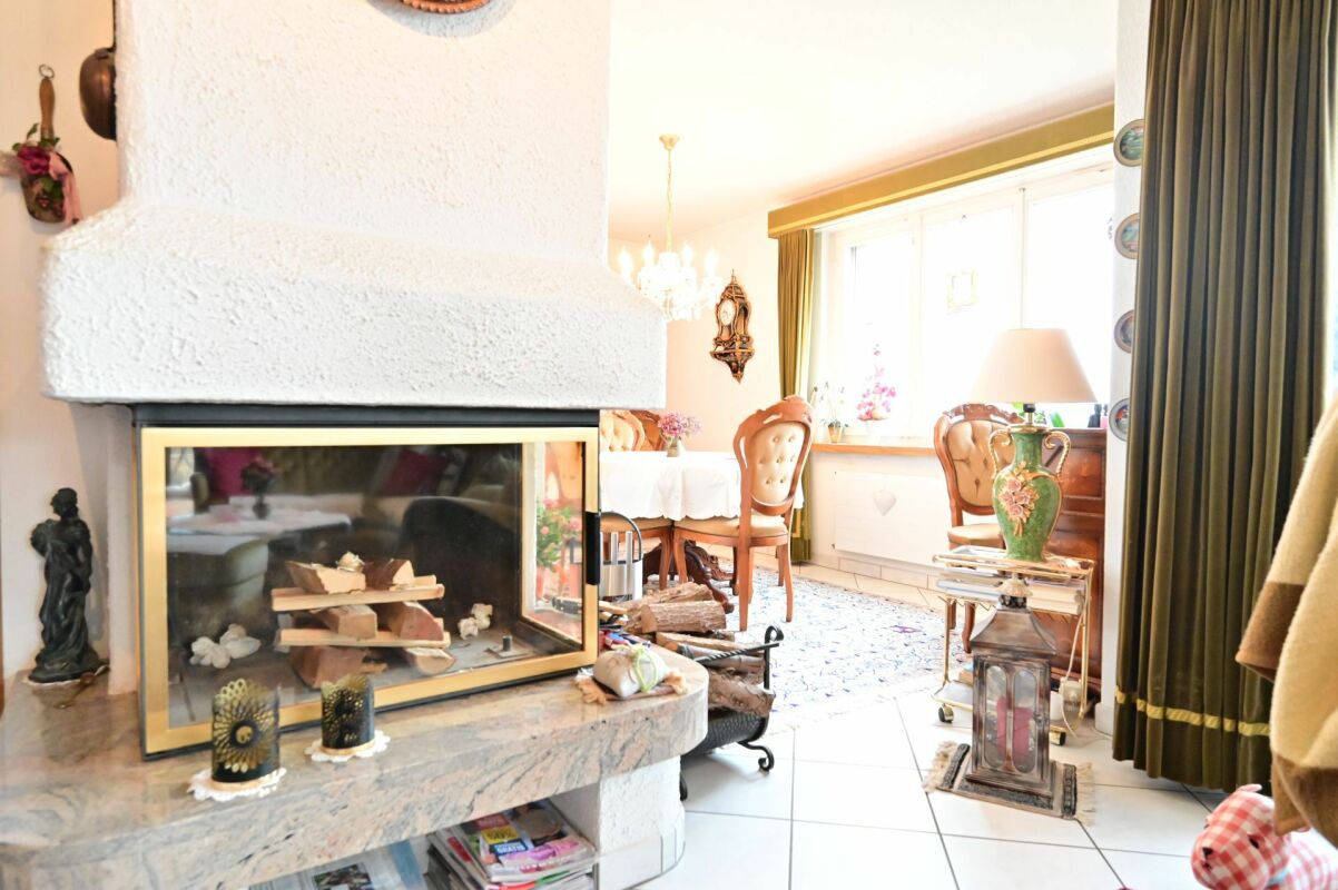 Wohnzimmer mit Kamin und Esstisch