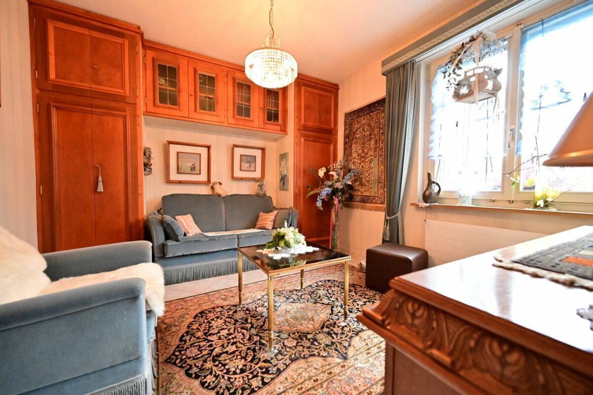 Gemütliches Wohnzimmer mit reichhaltiger Holzvertäfelung und klassischer Einrichtung