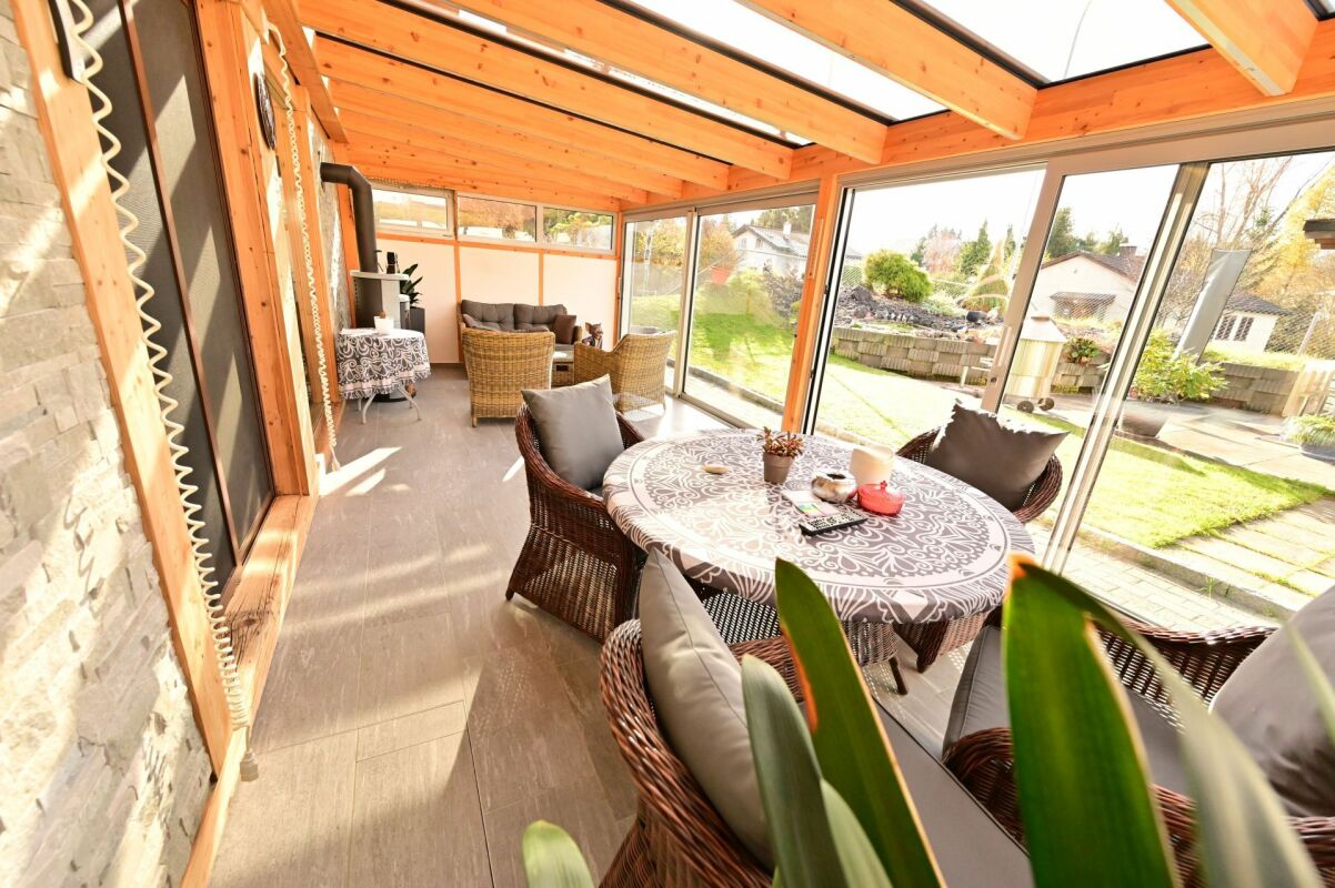 Verglaste Gartenlounge mit Sitzgruppe
