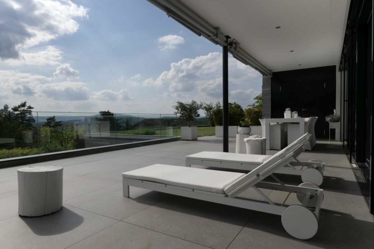 Große moderne Terrasse mit Liegen und Weitblick
