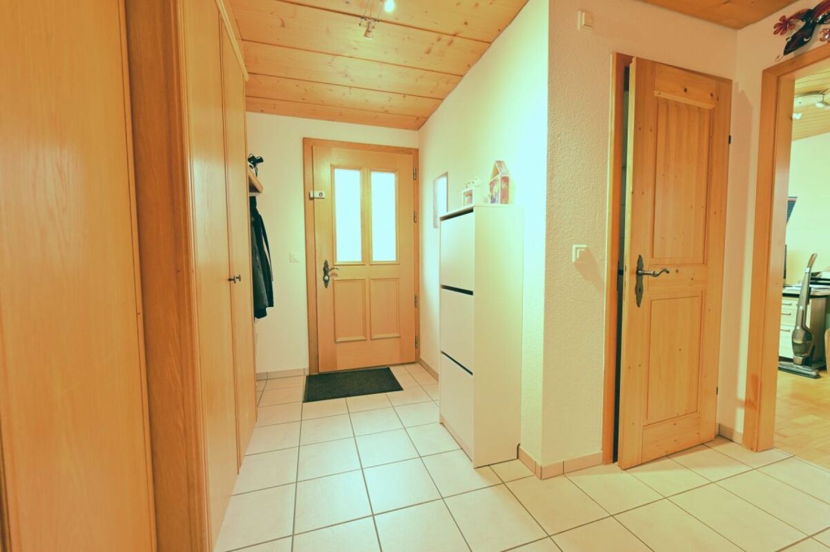 Heller Flur mit Holztüren und Fliesenboden
