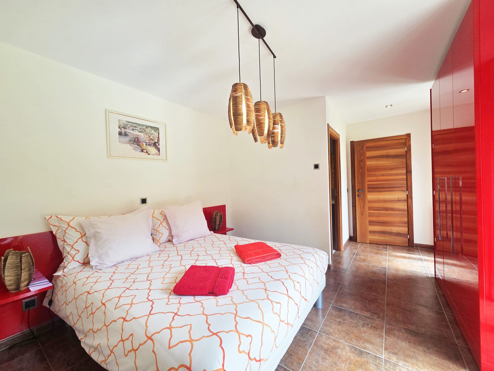 Modernes Schlafzimmer mit kräftigen roten Akzenten