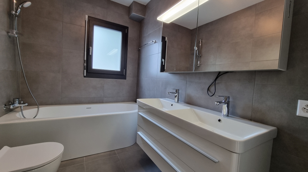 Modernes Badezimmer mit Badewanne und Doppelwaschtisch