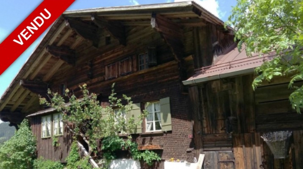 Alpines Holzhaus mit VENDU-Hinweis