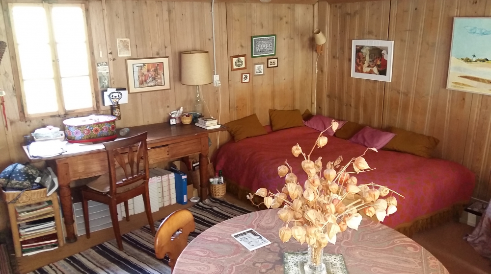 Gemütliches Holzschlafzimmer mit Schreibtisch und Bett