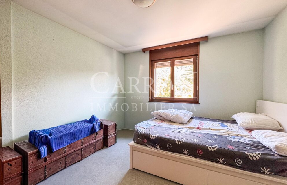 Schlichtes Schlafzimmer mit Bett und Holztruhen