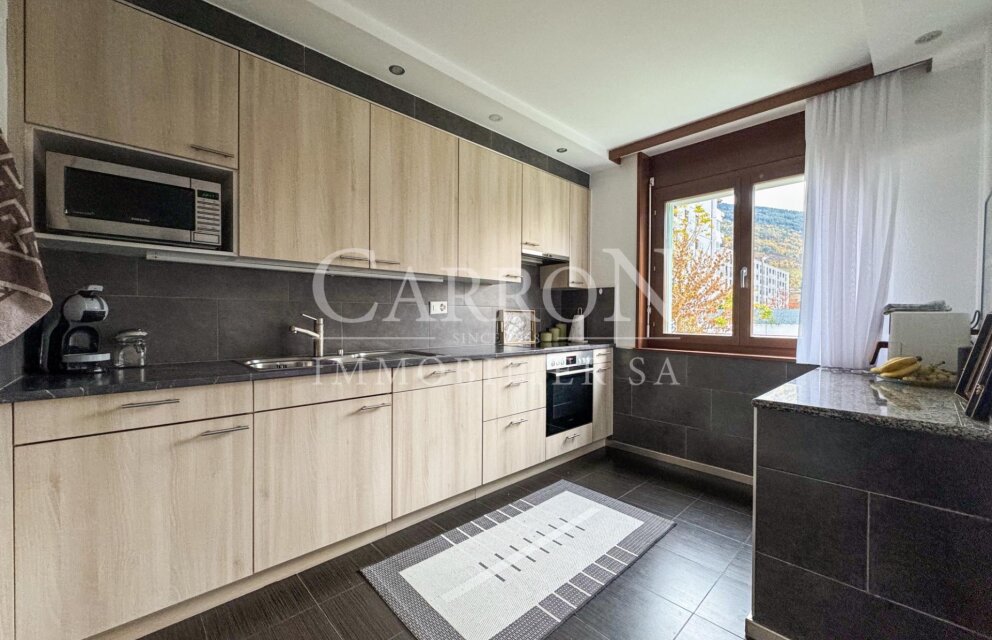 Moderne Küche mit heller Holzoptik und dunklen Oberflächen