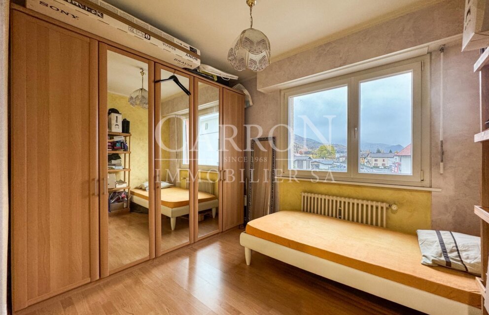 Schlafzimmer mit Kleiderschrank und Blick ins Freie