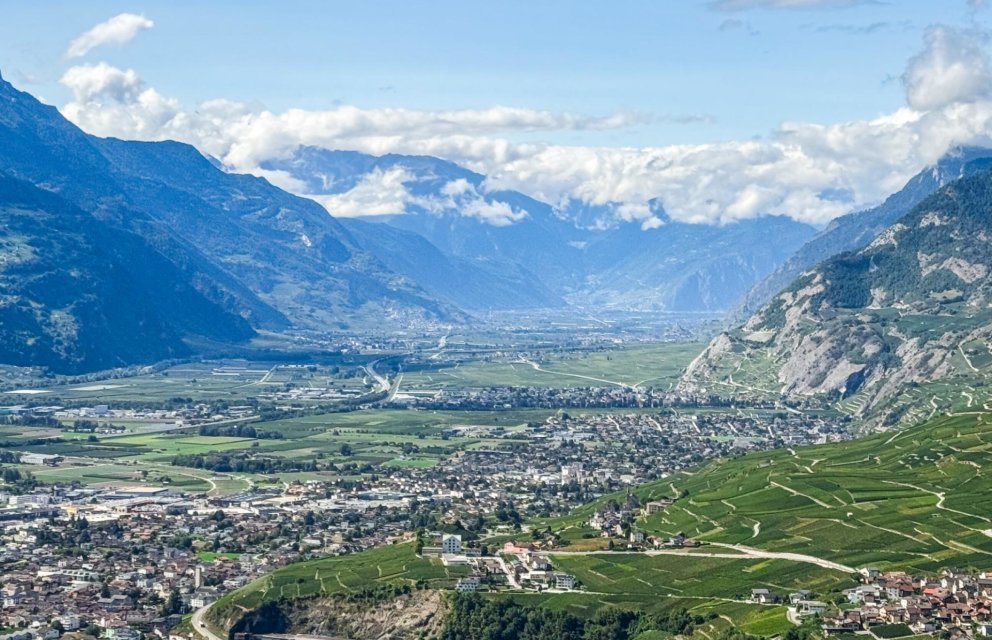 Alpenpanorama mit Tal und Stadt