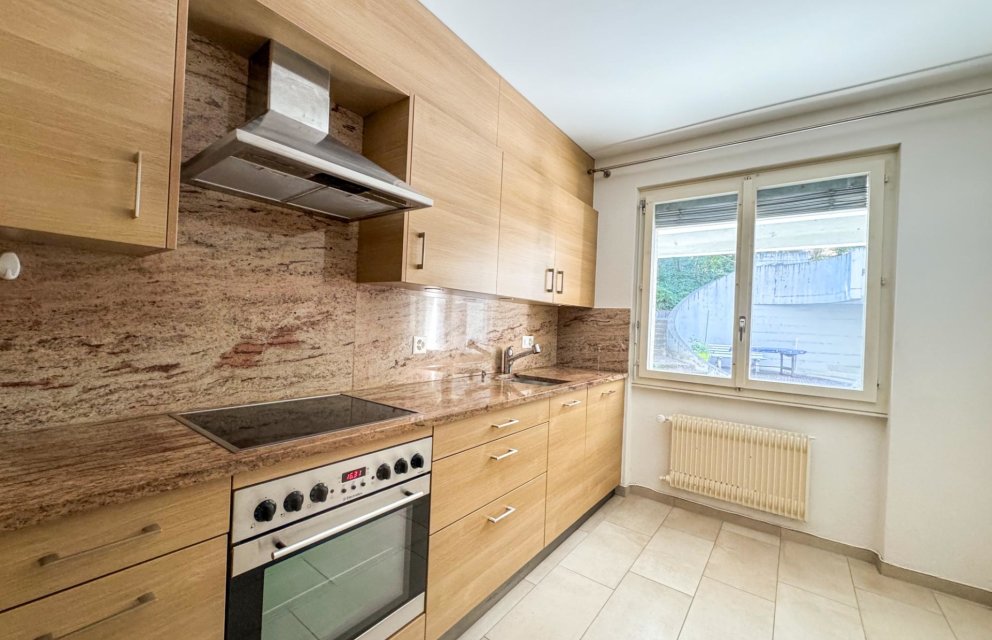 Helle Küche mit Holzfronten und Steinrückwand