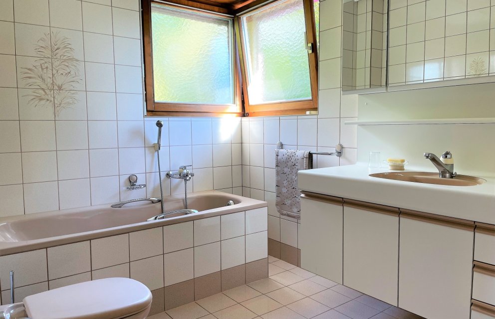 Badezimmer mit Wanne und Waschtisch