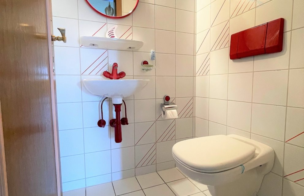 Kleines WC mit roter Akzentgestaltung