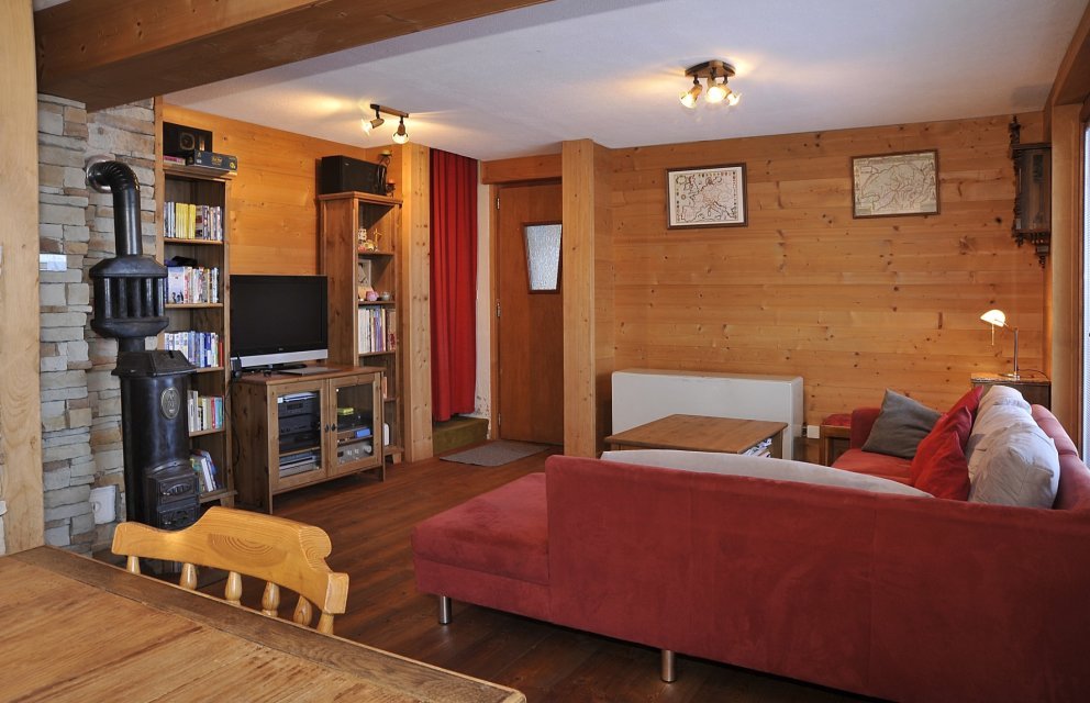 Gemütliches Wohnzimmer mit Holzverkleidung und Kaminofen