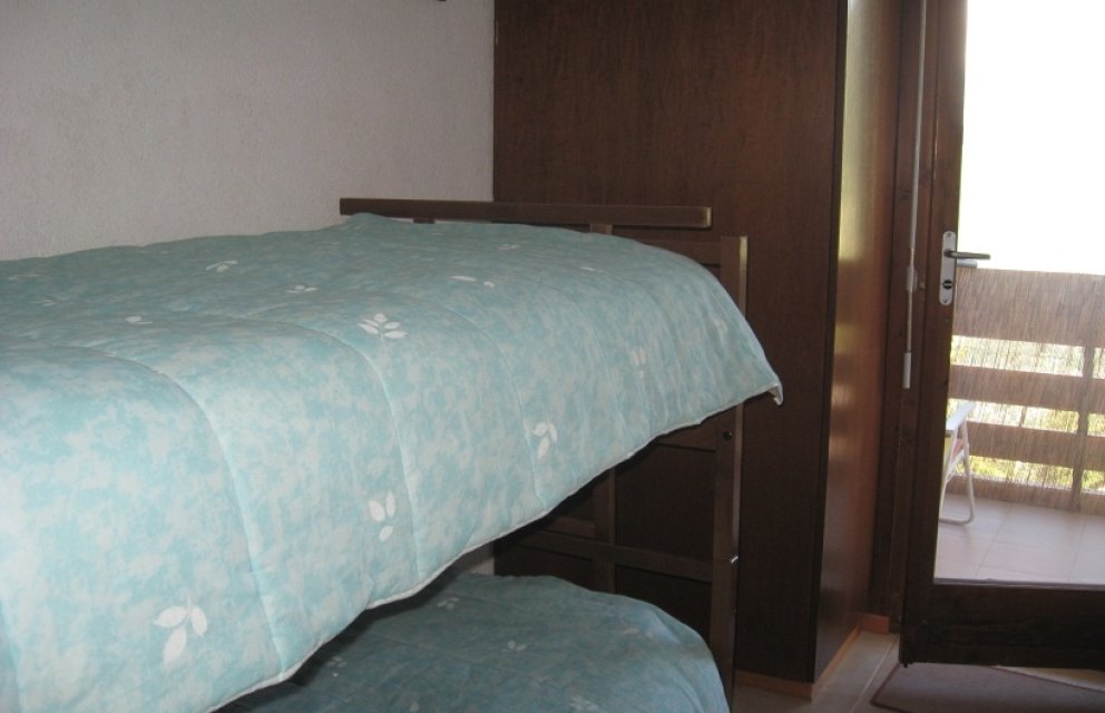 Schlafzimmer mit Etagenbett und Balkonzugang