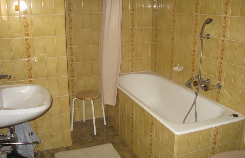 Gelb gefliestes Badezimmer mit Wanne