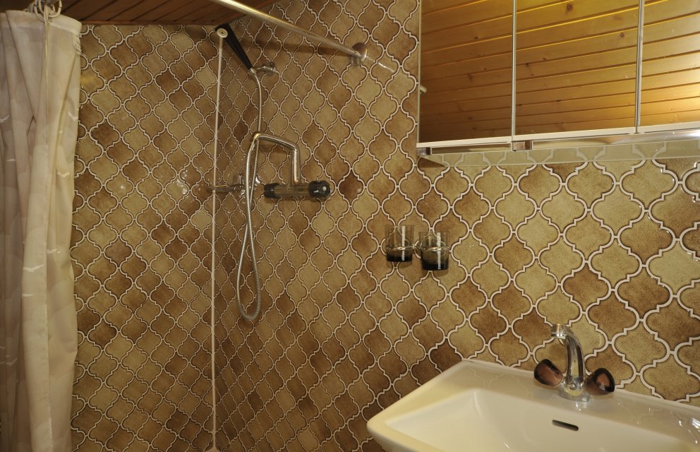Braunes Badezimmer mit Mosaikwand und Duschbereich