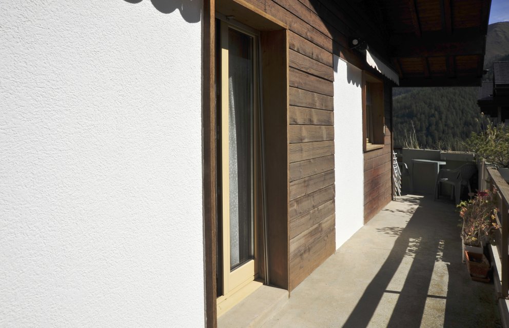 Balkon mit Holzfassade und Bergblick