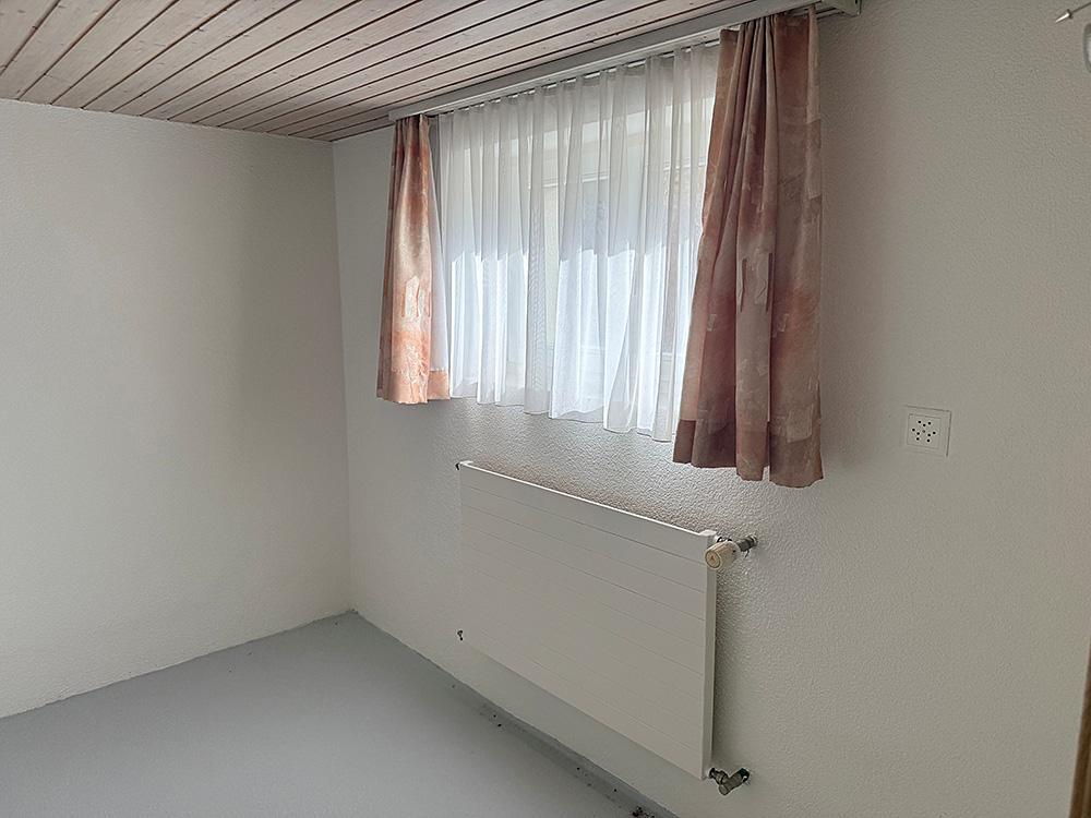 Kleiner leerer Raum mit Fenster und Heizkörper
