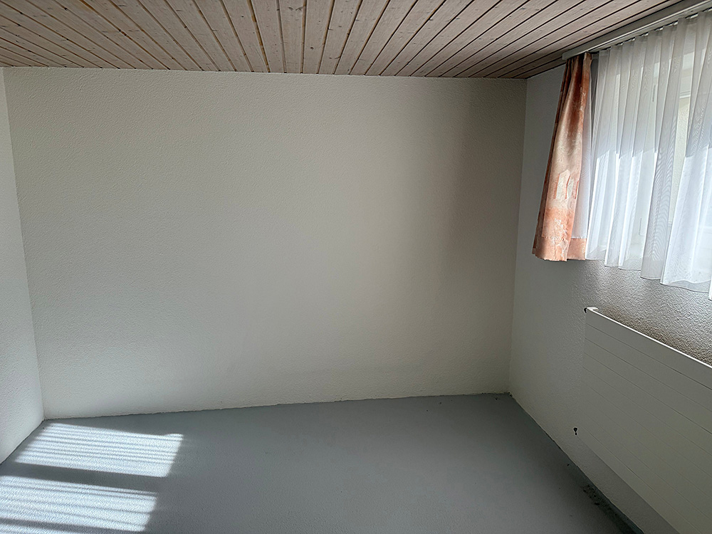 Leerer Innenraum mit Fenster und Heizkörper