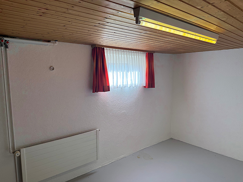 Kleiner Kellerraum mit Holzdecke und Fenster