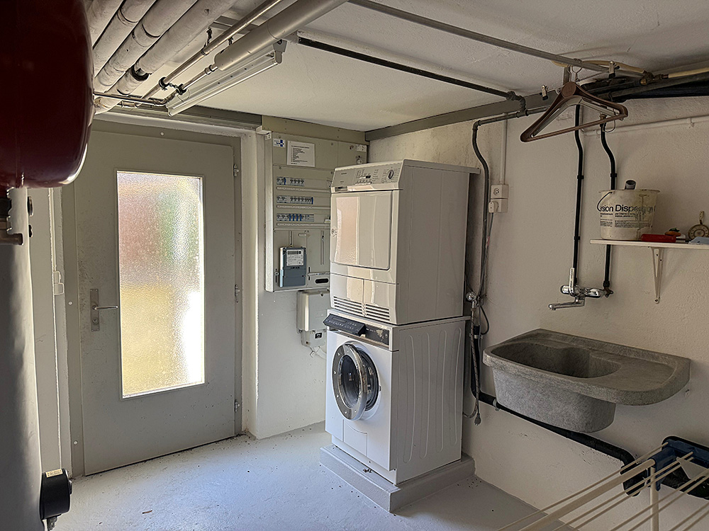 Hauswirtschafts-/Technikraum mit Waschmaschine und Tür