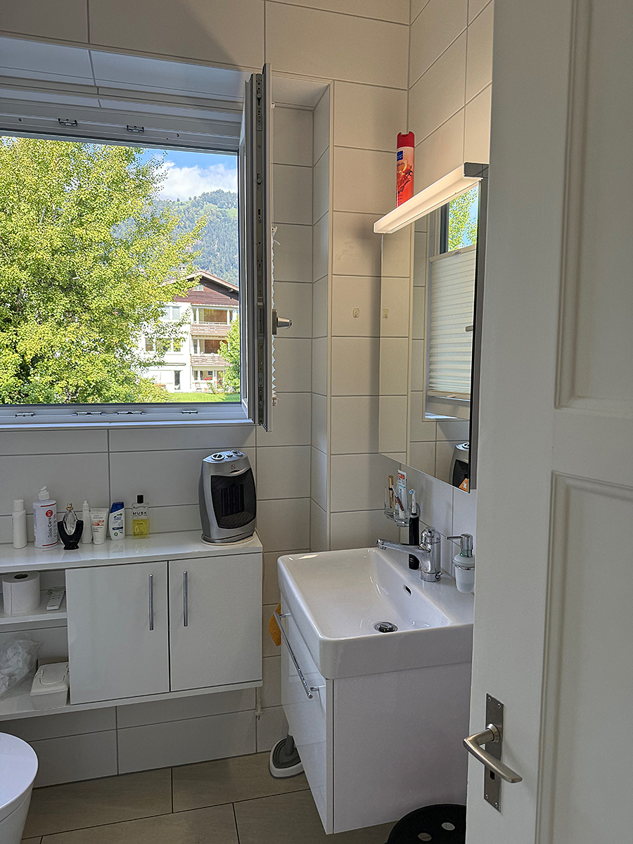 Helles Badezimmer mit Fenster und Waschtisch