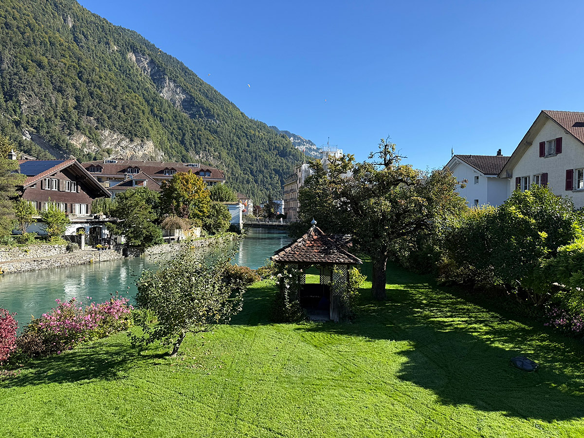 Flussblick mit Garten und Bergkulisse