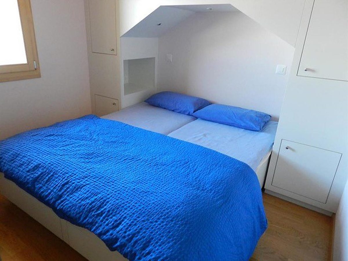 Kleines Schlafzimmer mit blauem Bett