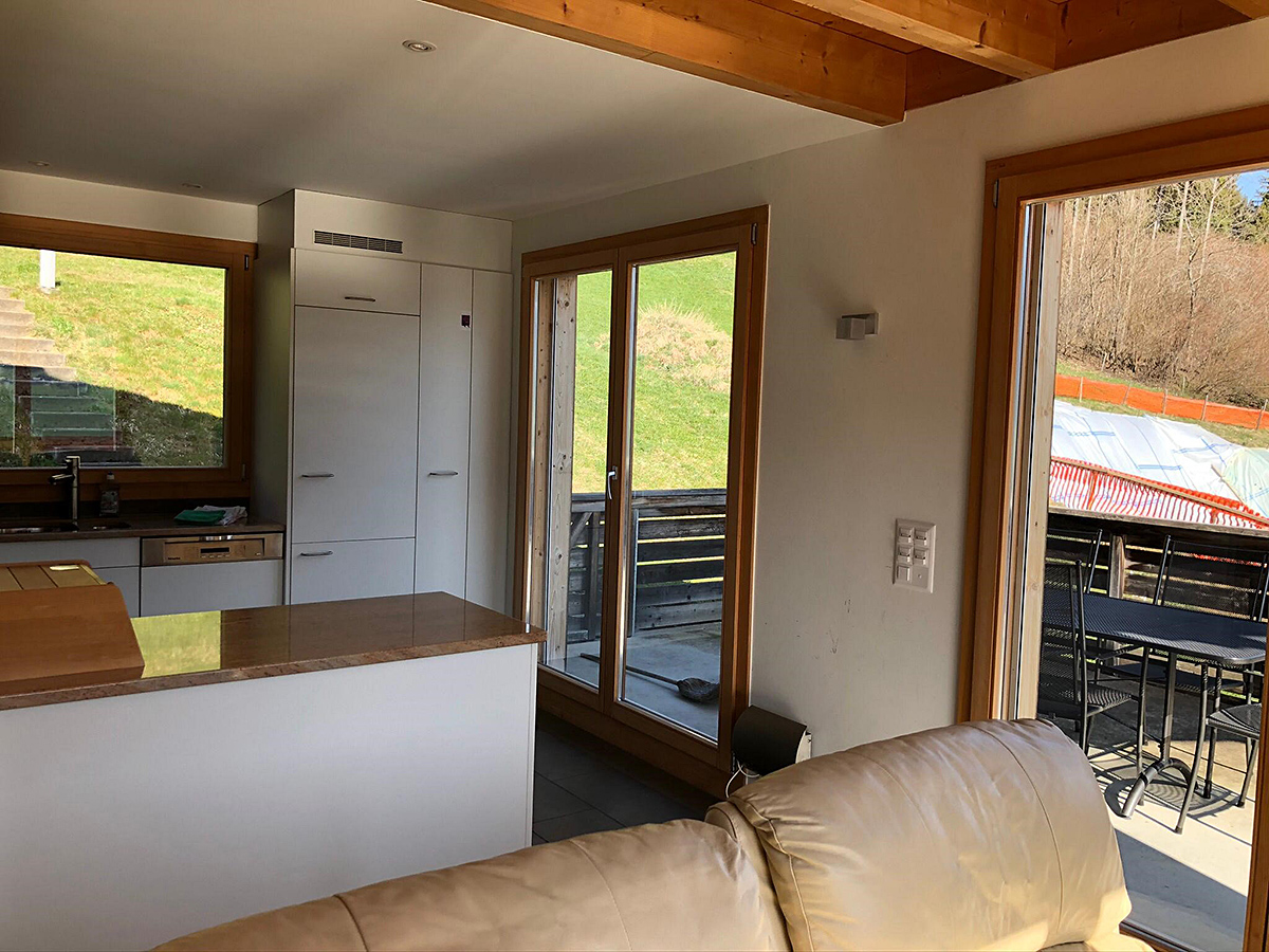 Offener Wohnbereich mit Küche und Zugang zur Terrasse