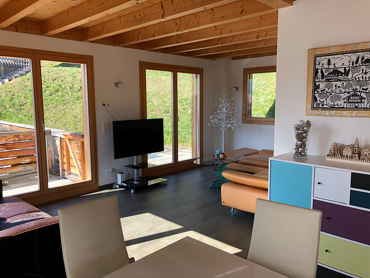 Wohnzimmer mit Holzdecke und großer Verglasung