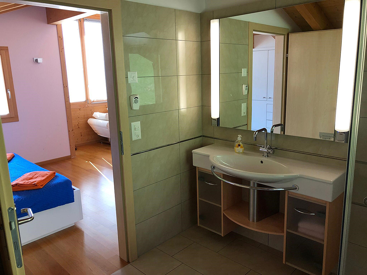 Badezimmer mit Waschtisch und Blick ins Schlafzimmer