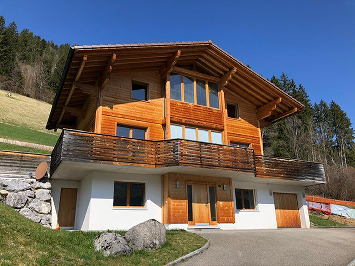 Berghaus mit Holzfassade und Balkon