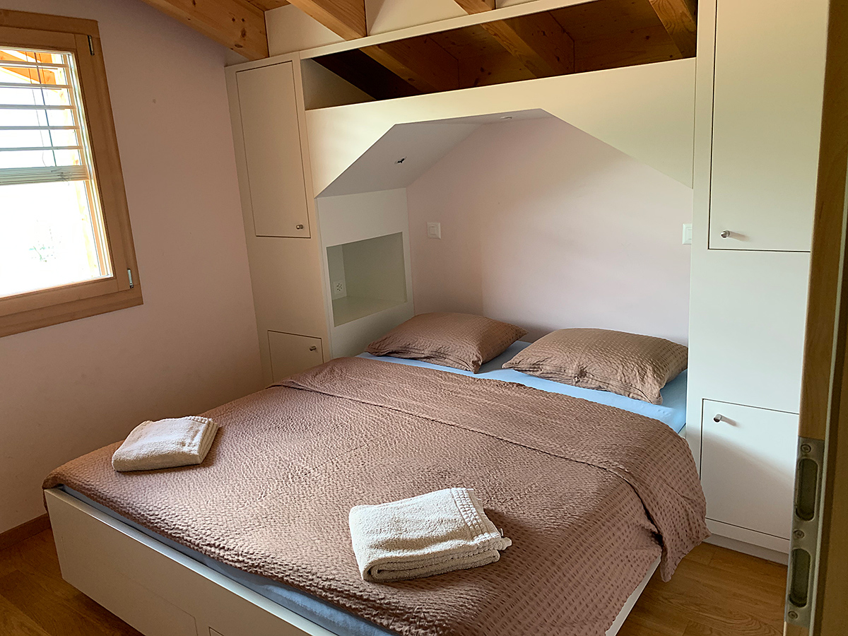 Kleines Schlafzimmer mit eingebautem Bett und Dachschrägen