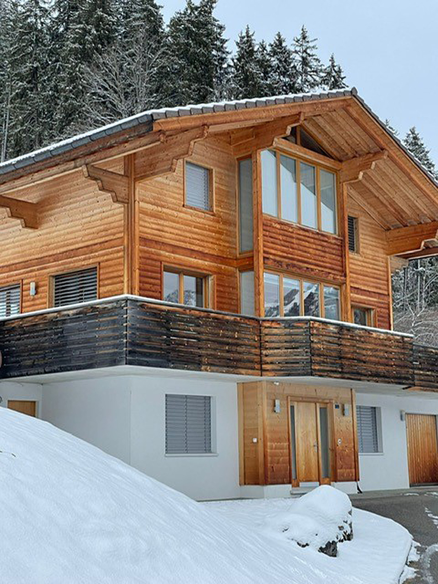 Alpenchalet mit Holzfassade und Schneelage