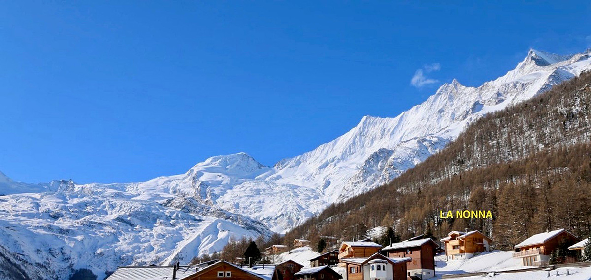 Bergdorf im Schnee mit Panoramablick auf alpine Gipfel