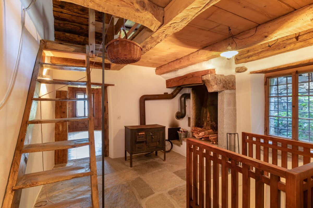Rustikaler Innenraum mit Galerie, Kamin und Holztreppe