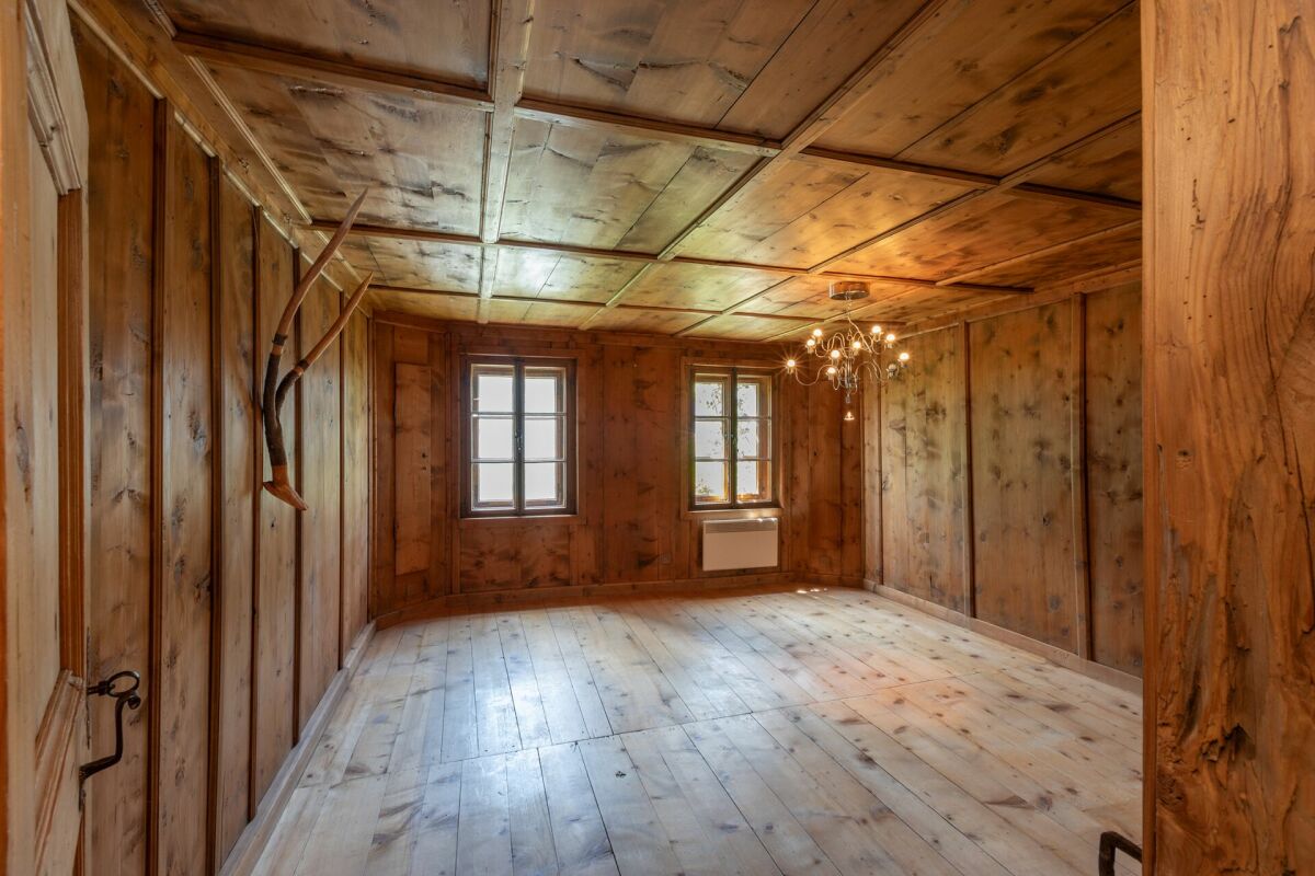 Holzvertäfelter Innenraum mit Fenstern und Kronleuchter