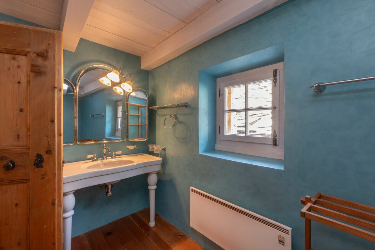 Kleines Badezimmer mit türkisfarbenen Wänden und Holzdetails