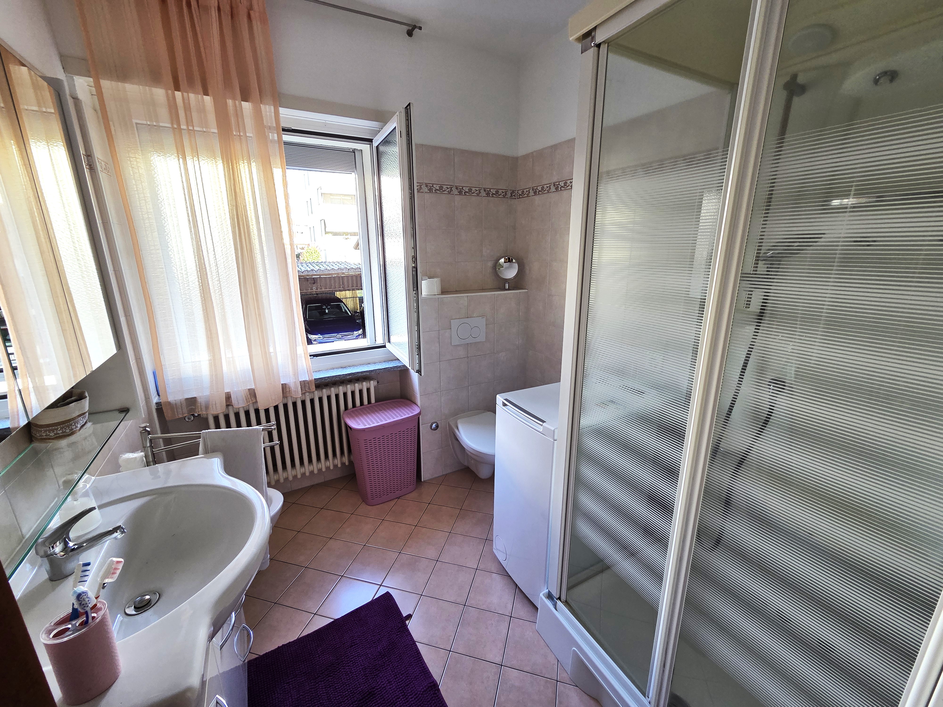 Helles Badezimmer mit Dusche und Fenster
