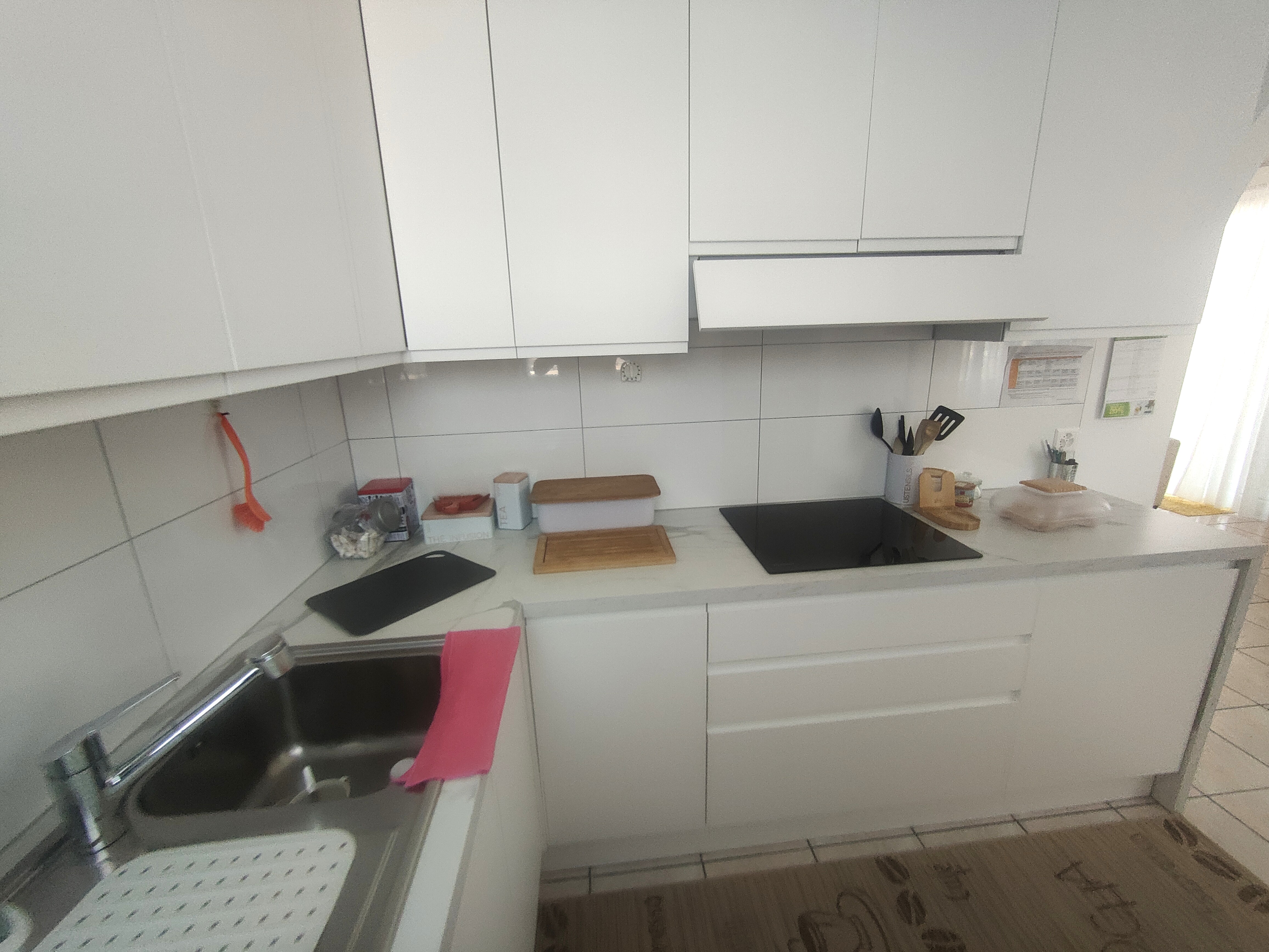 Moderne weiße Einbauküche mit Kochfeld